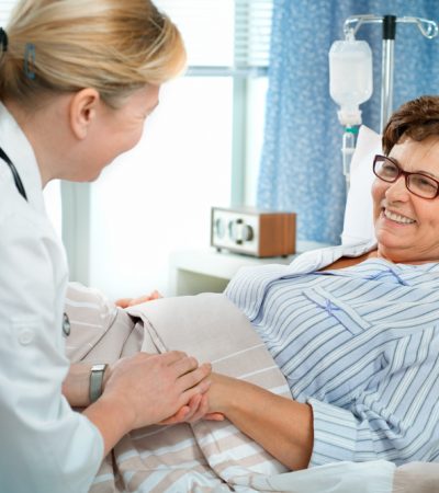 Doctor or nurse talking to patient in hospital